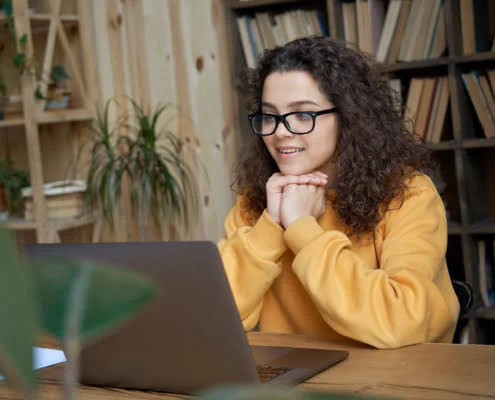 Jeune femme à lunettes étudiant à son bureau